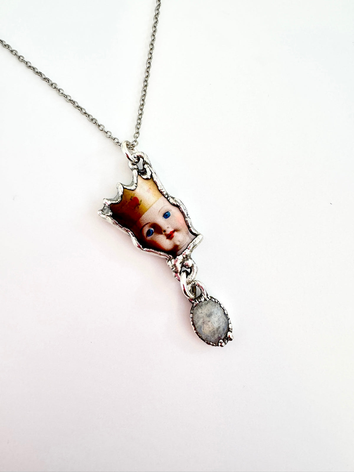 FOXLARK Weirdlings Collection doll head necklace with rainbow moonstone charm in fine silver, detailed close-up showing intricate design
