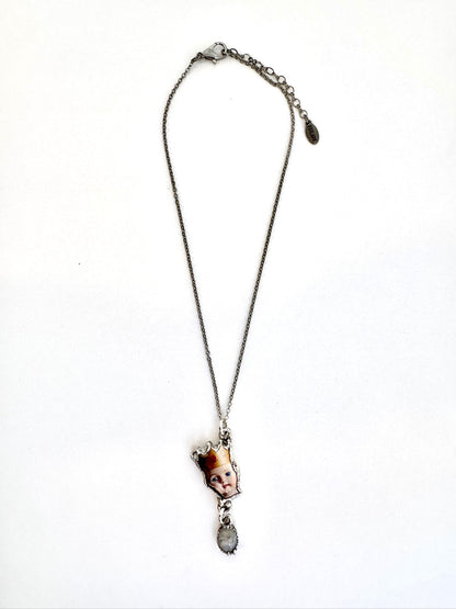 FoXLARK Weirdlings Collection doll head necklace with rainbow moonstone charm in fine silver, detailed close-up image.