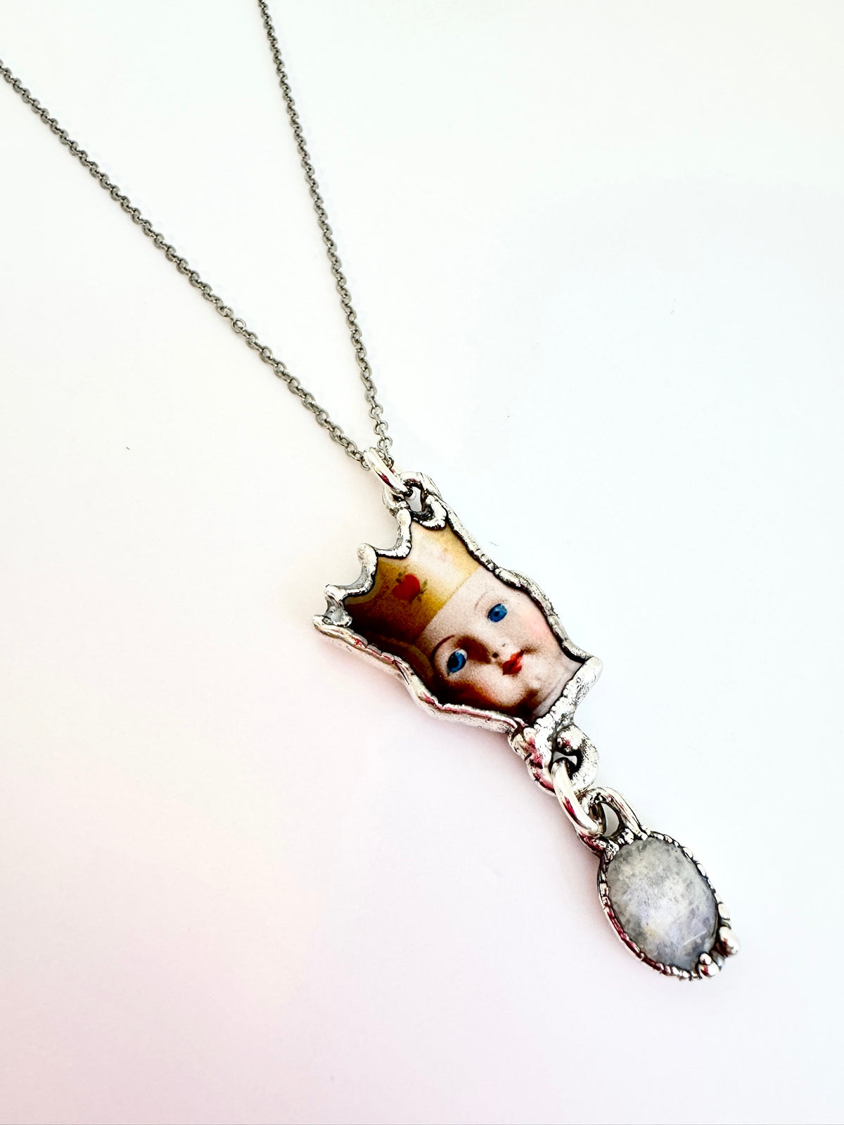 FoXLARK Weirdlings Collection doll head necklace with rainbow moonstone charm in fine silver, detailed pendant on chain.