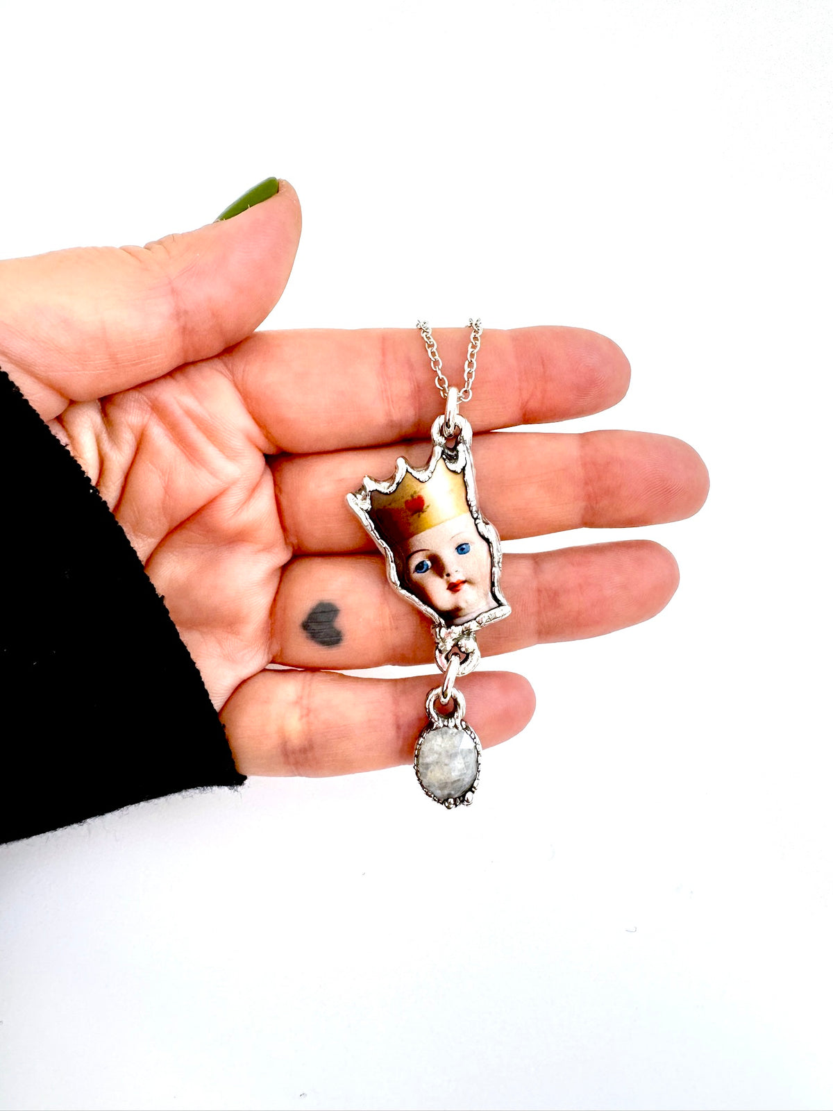 FoXLARK The Weirdlings Collection doll head necklace with rainbow moonstone charm in fine silver, detailed jewelry close-up image